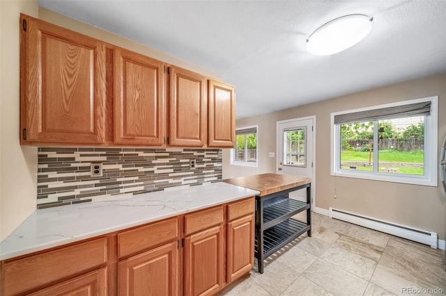 8051 S Kendall Blvd, Littleton, CO 80128 - kitchen with baseboard heating, decorative backsplash, light countertops, and brown cabinets