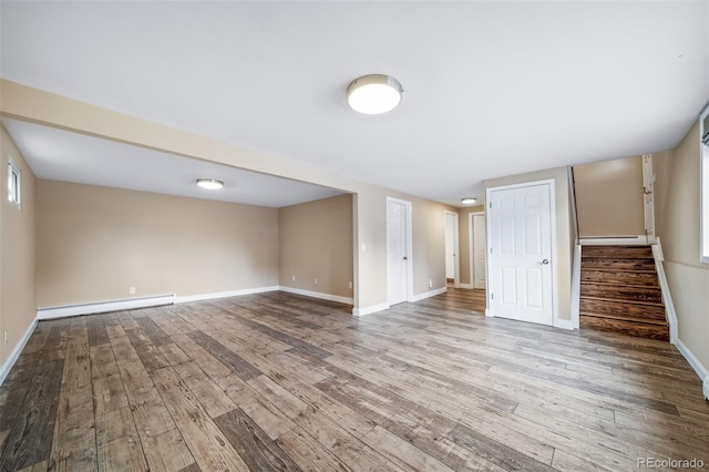 8051 S Kendall Blvd, Littleton, CO 80128 - below grade area featuring a baseboard heating unit, wood finished floors, and stairs