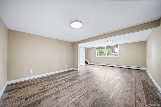 8051 S Kendall Blvd, Littleton, CO 80128 - spare room featuring a baseboard radiator, wood finished floors, and stairs