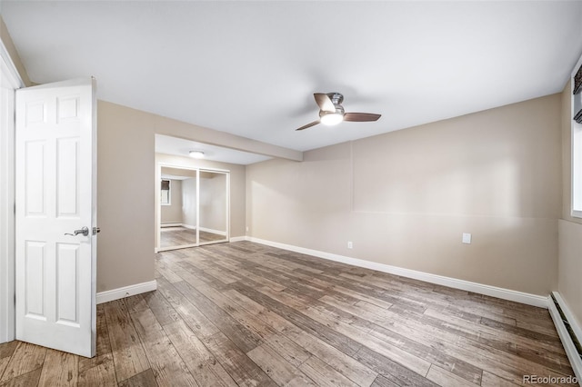 8051 S Kendall Blvd, Littleton, CO 80128 - unfurnished bedroom featuring baseboard heating, hardwood / wood-style flooring, a closet, and a ceiling fan