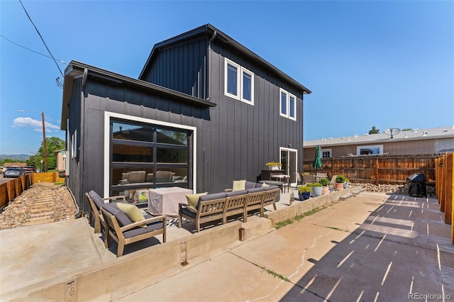 550 S Raleigh St, Denver, CO 80219 - back of property featuring an outdoor hangout area, board and batten siding, and a patio