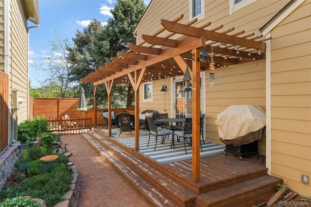 wooden deck featuring a pergola, fence, and outdoor dining area