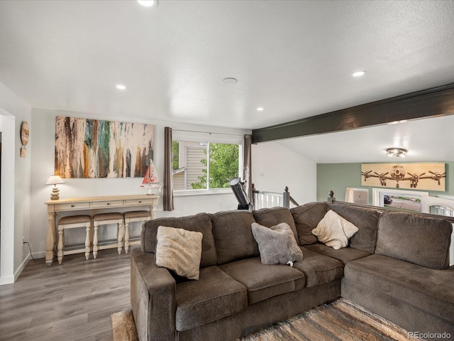 living area featuring wood finished floors, recessed lighting, baseboards, and beam ceiling