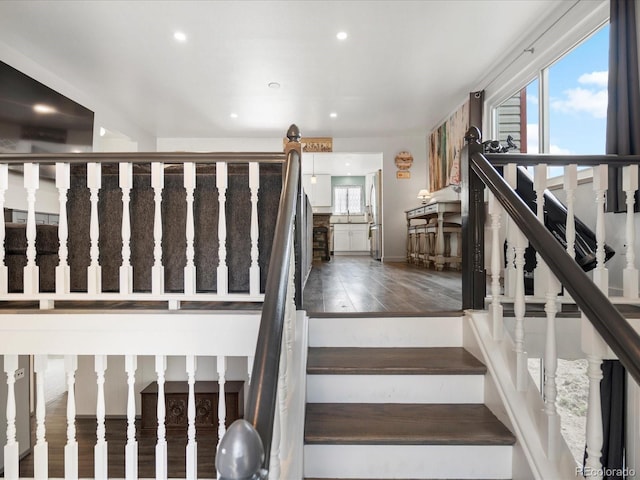 stairway featuring plenty of natural light, recessed lighting, and wood finished floors