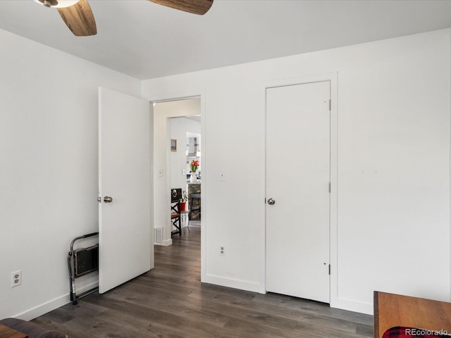 bedroom featuring dark wood-type flooring, baseboards, and a ceiling fan