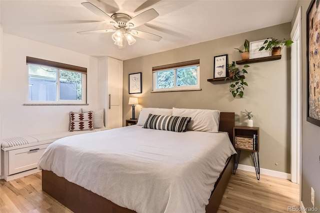 bedroom featuring ceiling fan, baseboards, and light wood finished floors