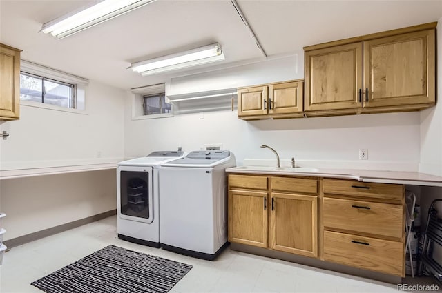 laundry room featuring cabinet space, washing machine and dryer, and a sink