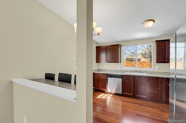 243 Madison Dr, Bennett, CO 80102 - kitchen featuring wood finished floors, a textured ceiling, stainless steel dishwasher, and a sink
