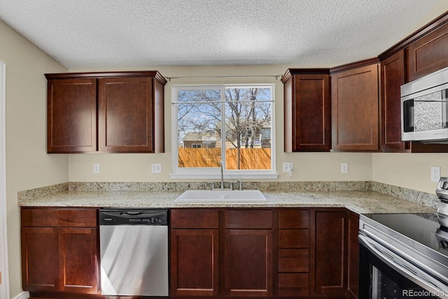 243 Madison Dr, Bennett, CO 80102 - kitchen featuring appliances with stainless steel finishes, a sink, a textured ceiling, and light countertops