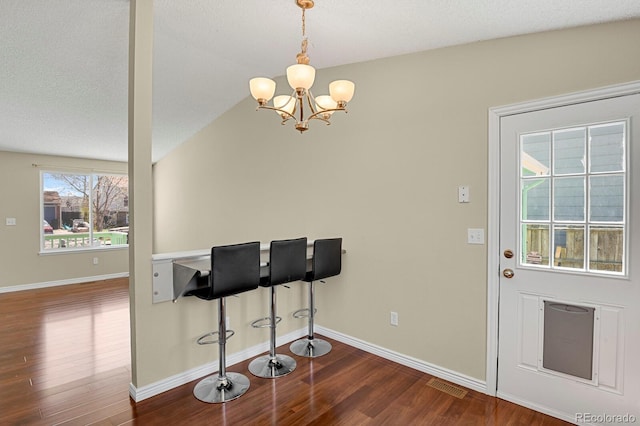 243 Madison Dr, Bennett, CO 80102 - dining area featuring a chandelier, dark wood finished floors, visible vents, and baseboards