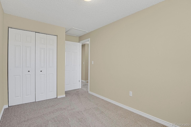 243 Madison Dr, Bennett, CO 80102 - unfurnished bedroom featuring carpet floors, a closet, baseboards, attic access, and a textured ceiling