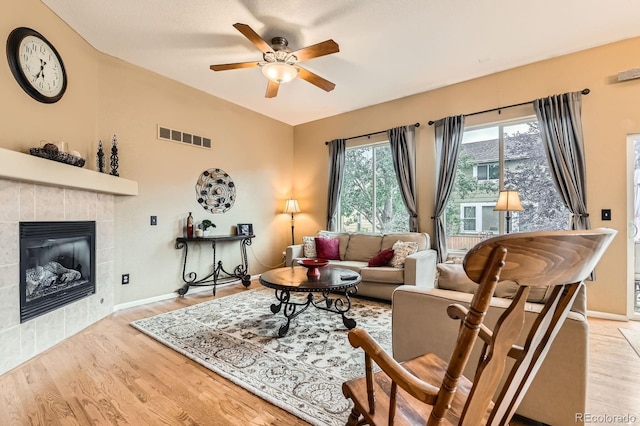 10463 Nucla St, Commerce City, CO 80022 - living area featuring ceiling fan, a tiled fireplace, and wood finished floors