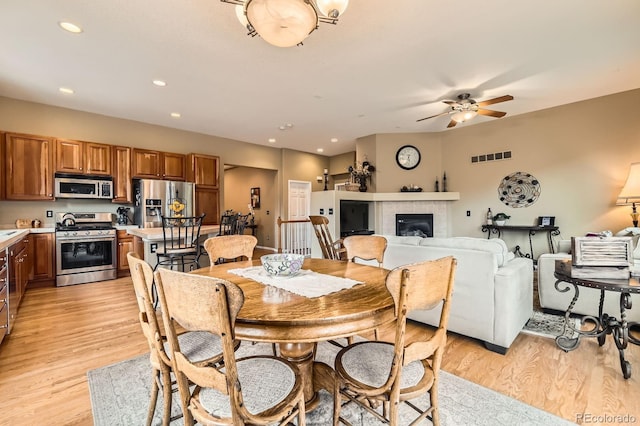 10463 Nucla St, Commerce City, CO 80022 - dining area featuring ceiling fan, light wood-style floors, a tiled fireplace, and recessed lighting