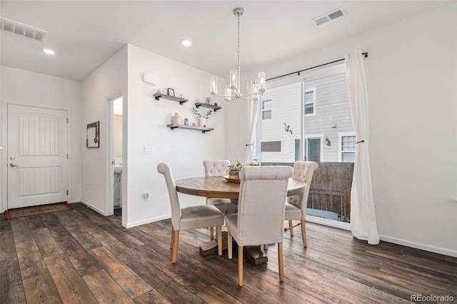 dining space featuring dark wood-type flooring and an inviting chandelier