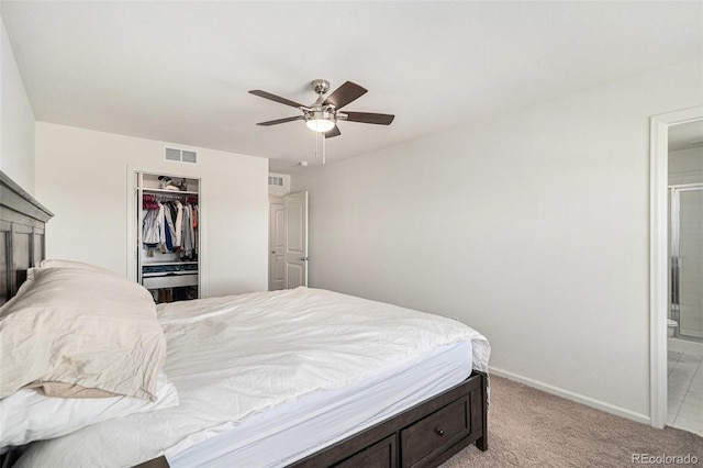 carpeted bedroom with connected bathroom, a spacious closet, a closet, and ceiling fan