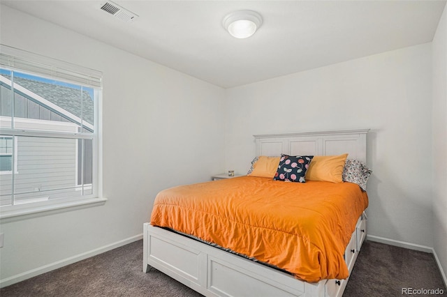 bedroom featuring dark colored carpet, visible vents, and baseboards