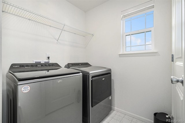 washroom featuring laundry area, separate washer and dryer, and baseboards