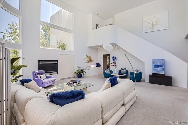 living room with a high ceiling and light carpet