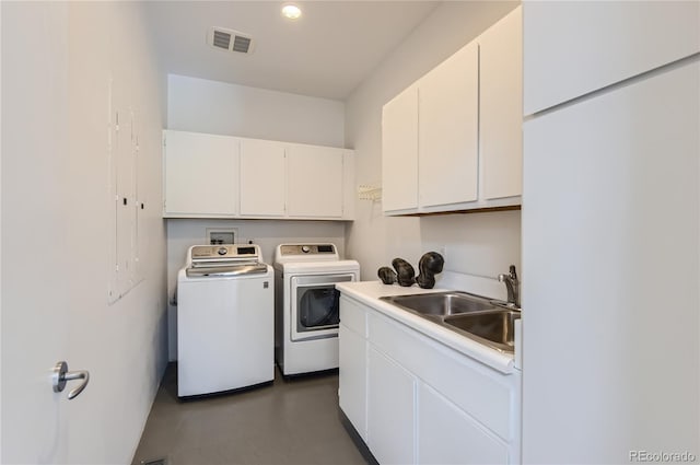 washroom with cabinets, sink, and washing machine and clothes dryer