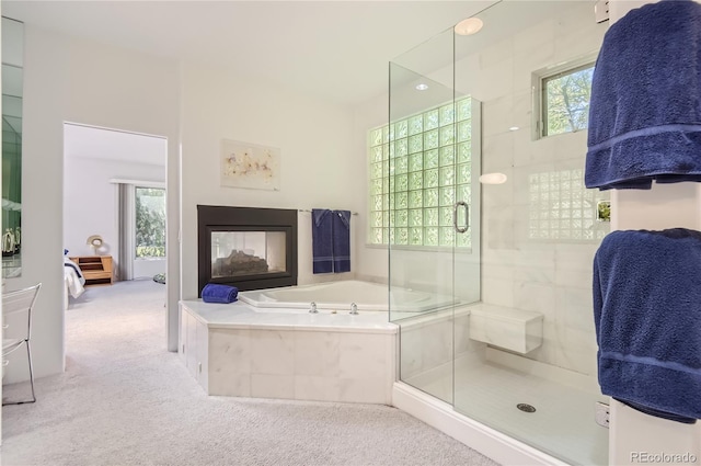 bathroom featuring a multi sided fireplace, a healthy amount of sunlight, and separate shower and tub