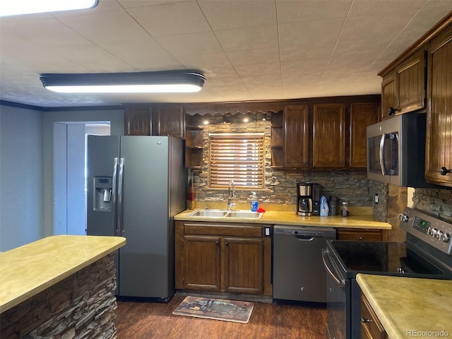 kitchen with dark wood-type flooring, dark brown cabinetry, sink, appliances with stainless steel finishes, and backsplash