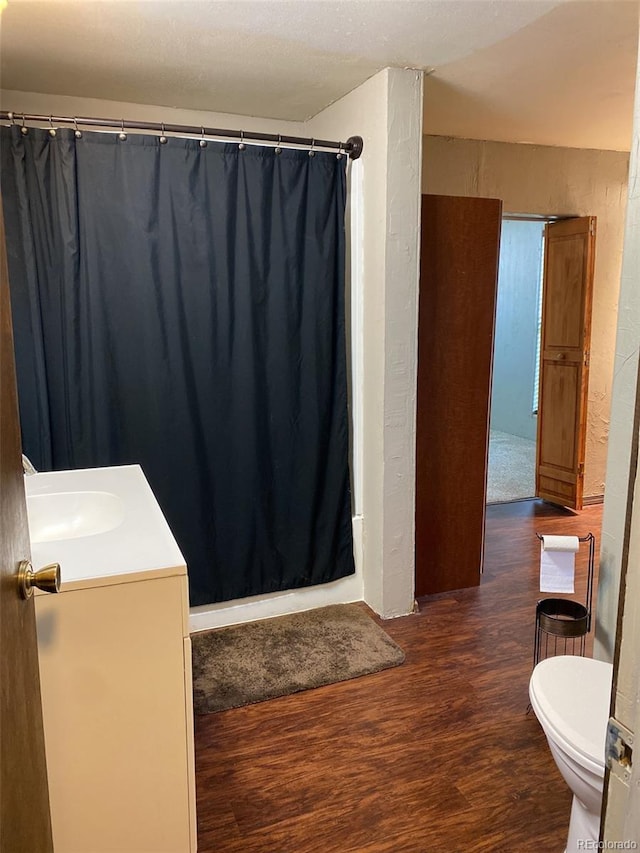 bathroom featuring vanity, hardwood / wood-style floors, and toilet