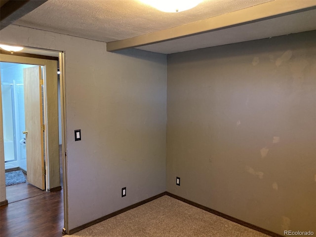 empty room with beamed ceiling and a textured ceiling