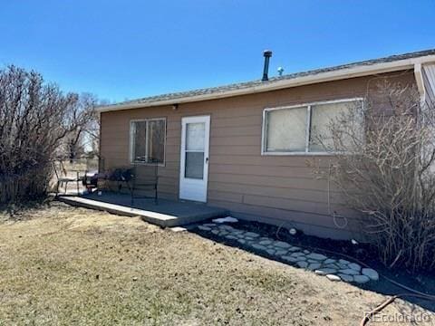 back of property featuring a lawn and a patio area