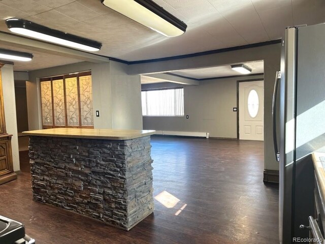 bar with baseboard heating, dark hardwood / wood-style floors, and stainless steel fridge