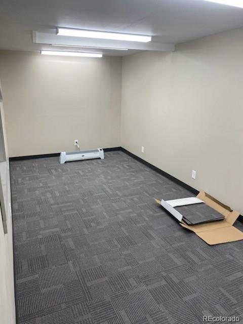 interior space with baseboard heating and dark colored carpet