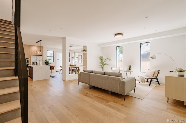 2530 Chase, Edgewater, CO 80215 - living room featuring stairs, light wood-type flooring, and plenty of natural light