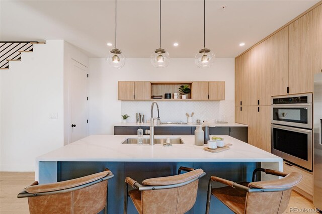 2530 Chase, Edgewater, CO 80215 - kitchen with light brown cabinets, double oven, a breakfast bar area, light wood finished floors, and tasteful backsplash