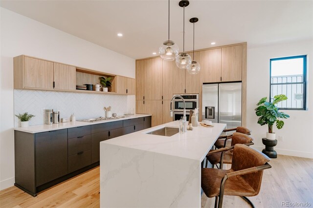 2530 Chase, Edgewater, CO 80215 - kitchen featuring light brown cabinets, a breakfast bar area, light wood-style flooring, a sink, and recessed lighting