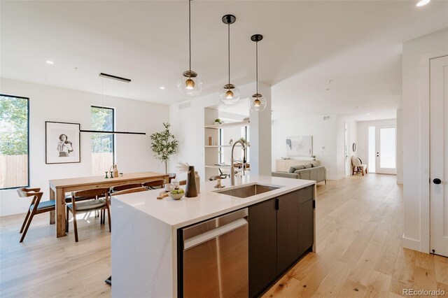 2530 Chase, Edgewater, CO 80215 - kitchen featuring a sink, stainless steel dishwasher, light countertops, decorative light fixtures, and light wood finished floors