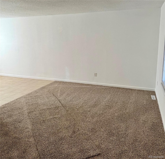 empty room with carpet and a textured ceiling