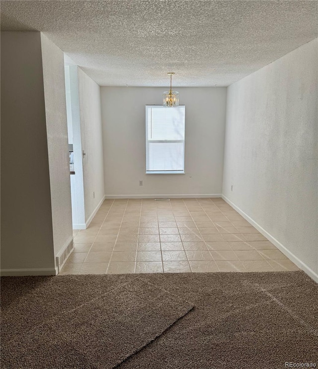 empty room featuring light colored carpet and a textured ceiling