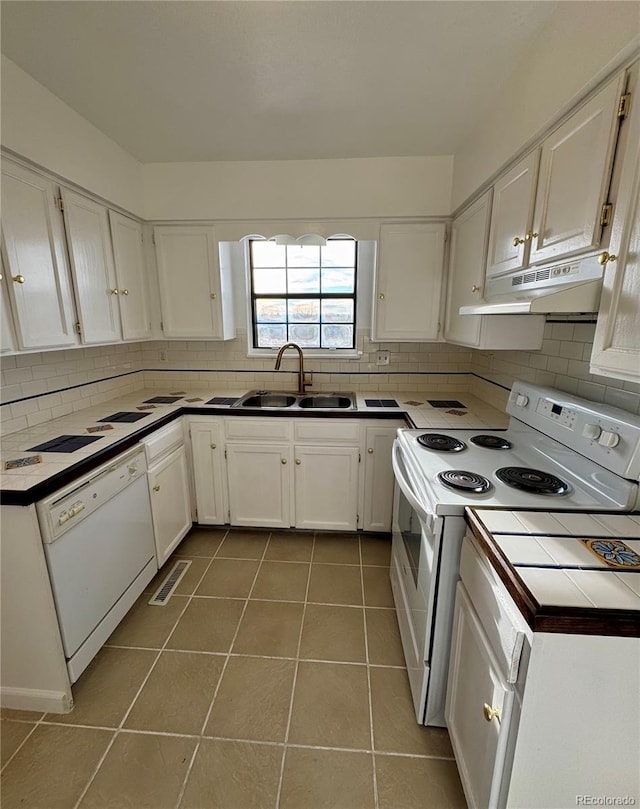 kitchen featuring white cabinets, white appliances, sink, and light tile patterned floors