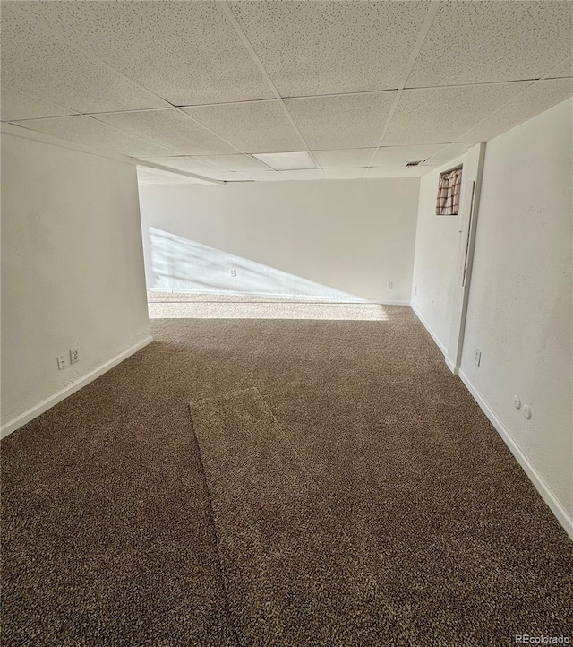 carpeted empty room with a paneled ceiling