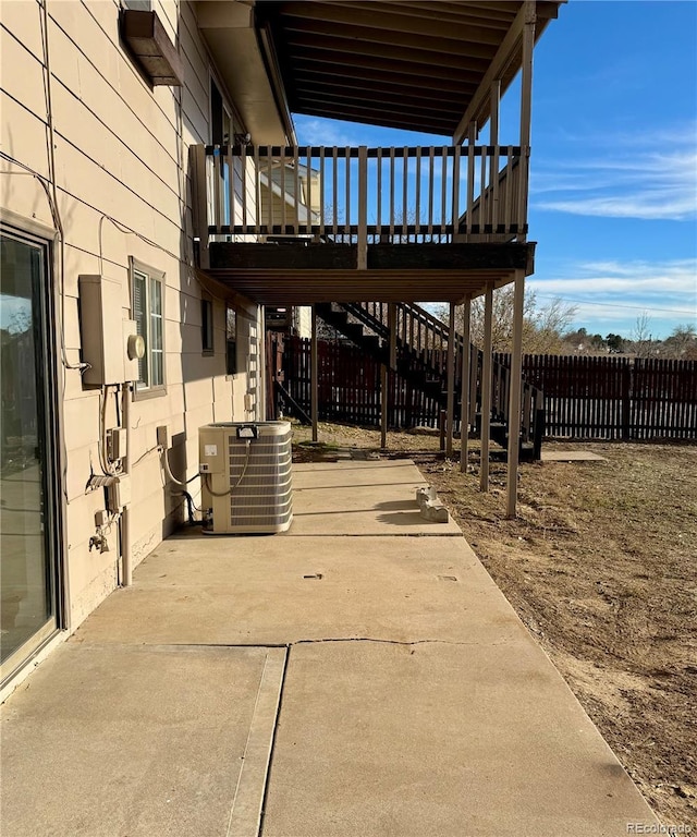 view of patio with cooling unit and a deck