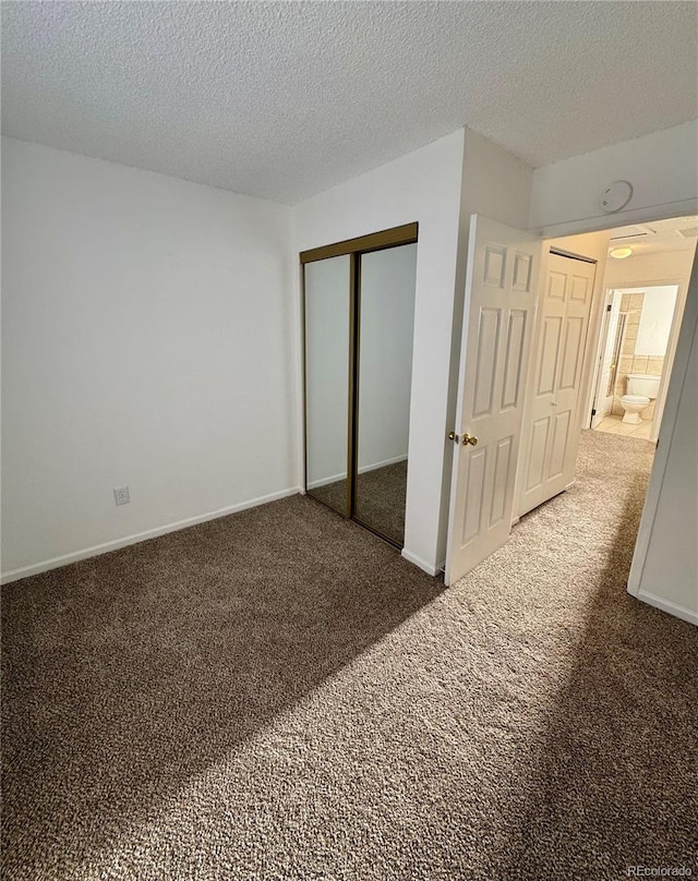 unfurnished bedroom featuring dark carpet and a textured ceiling