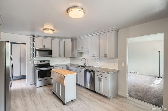 1785 S Zuni St, Denver, CO 80223 - kitchen with appliances with stainless steel finishes, wooden counters, gray cabinetry, and tasteful backsplash