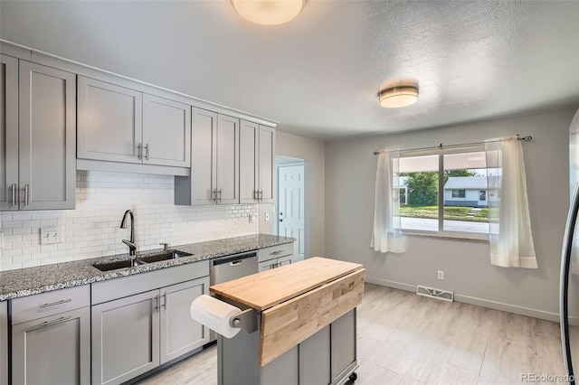 1785 S Zuni St, Denver, CO 80223 - kitchen featuring gray cabinets, backsplash, light stone counters, and stainless steel dishwasher