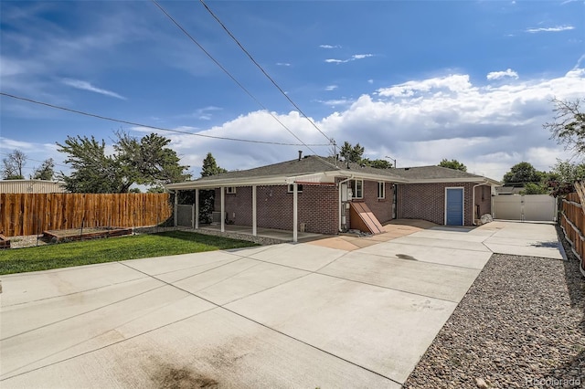 1785 S Zuni St, Denver, CO 80223 - back of property featuring a patio, driveway, brick siding, and a gate