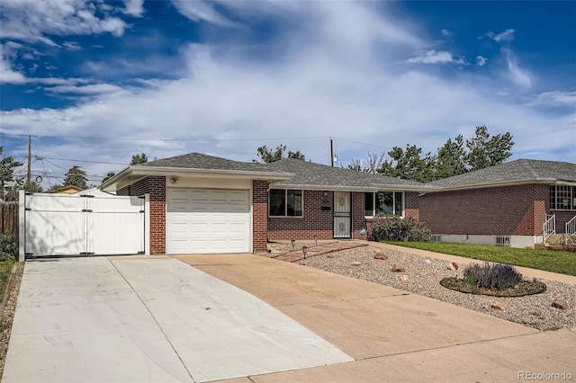 1785 S Zuni St, Denver, CO 80223 - single story home featuring brick siding, an attached garage, concrete driveway, a gate, and roof with shingles