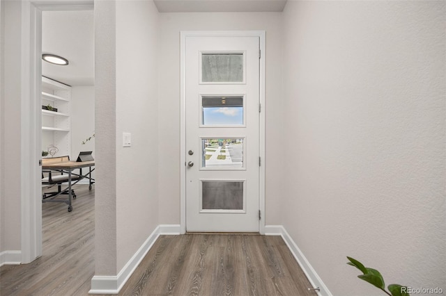 entryway featuring baseboards and wood finished floors