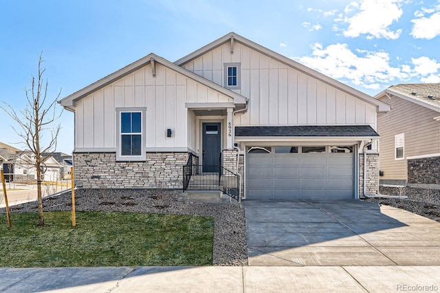 view of front of property with a shingled roof, concrete driveway, a garage, stone siding, and board and batten siding