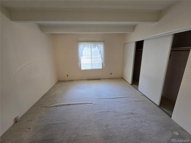 2525 S Dayton Way Unit 2307, Denver, CO 80231 - unfurnished bedroom featuring beamed ceiling, light colored carpet, and a closet