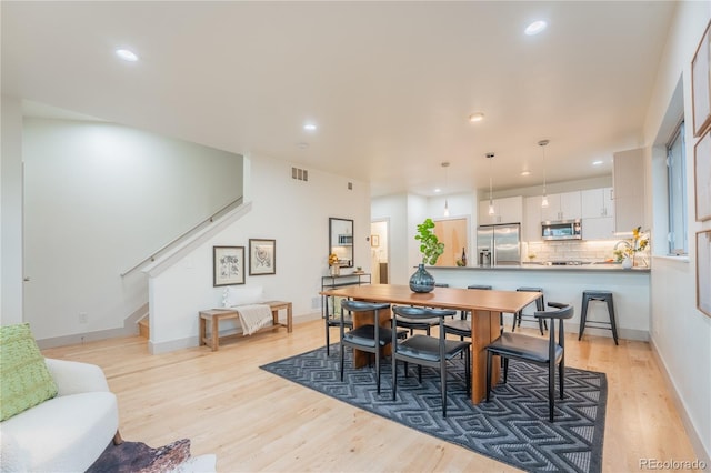 6892 Juniper Ct, Arvada, CO 80007 - dining area featuring light wood-style floors, stairway, and recessed lighting