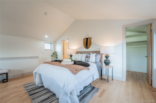 6892 Juniper Ct, Arvada, CO 80007 - bedroom with a spacious closet, wood finished floors, lofted ceiling, and a closet