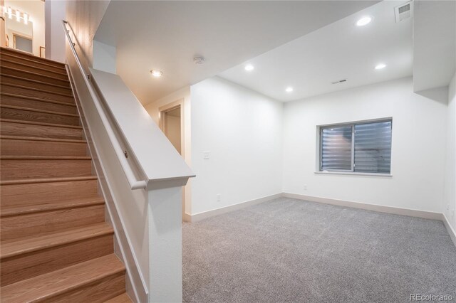 6892 Juniper Ct, Arvada, CO 80007 - below grade area featuring stairway, carpet, and recessed lighting